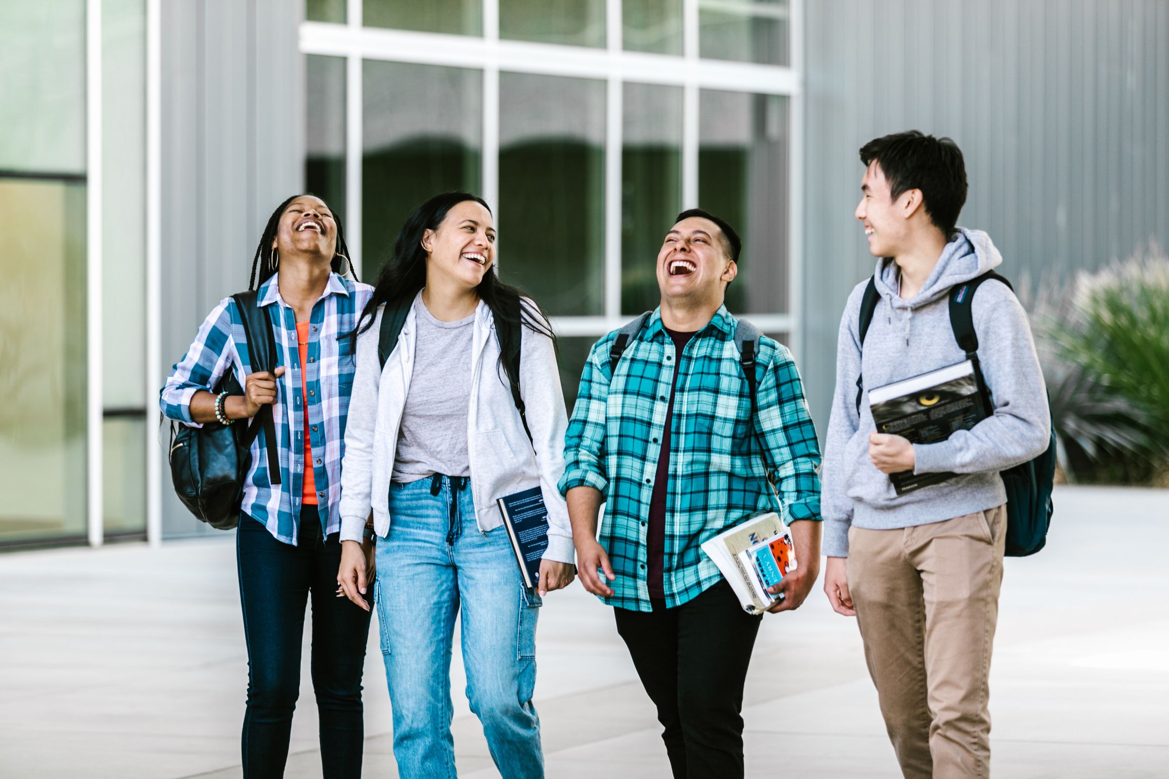 A diverse group of college students walking together and laughing on campus